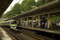 Japan, Honshu, Tokyo, commuters train arriving at station platform.