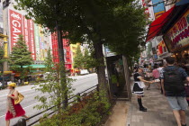 Japan, Tokyo, Akihabara, young woman in maid costume handing out flyers for a maid cafe.