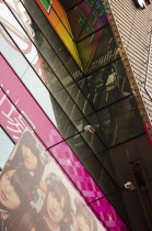 Japan, Tokyo, Akihabara, facade of the AKB 48 idol group store, reflection of busy traffic scene in glass fronted building.