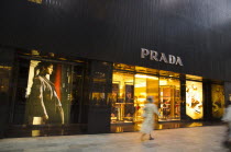 Japan, Tokyo, Ginza, shopper walking by the Prada store on Chou-dori Avenue. **Editorial Use Only**