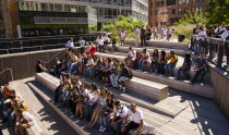 USA, New York, Manhattan, West Side, High Line Park, 10th Ave Square, Theater area with high school students sat waiting for performance.