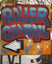 Art, Graffiti, former parcel delivery warehouse converted into roller disco with the walls decorated by local graffiti artists. Sign pointing to entrance of Roller Central.