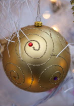 Festivals, Christmas, Decorations, gold coloured, bauble with white tinsel and fairy lights.