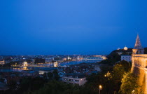 Hungary, Budapest, Buda Castle District, view over Danube and Pest from Fishermen's Bastion with Memorial Chain Bridge illuminated.