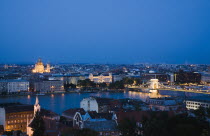 Hungary, Budapest, Buda Castle District: view over Danube and Pest with St Stephen's Basilica illuminated.