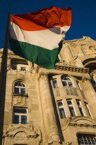 Hungary, Budapest, Hungarian Flag flying with Art Nouveau facade behind  in central Pest.