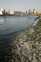 UAE , Dubai, Water's edge at entrance to Creek with  skyline behind.