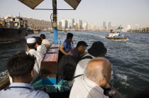 UAE , Dubai, Abra water taxis passing  on the Creek with Twin Towers and skyline behind.