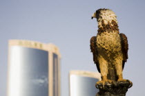 UAE , Dubai, Falcon ststue on the Creek with Twin Towers shopping mall behind.