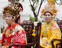 Thailand, Bangkok, Women in Chinese costume carried in parade celebrating local temple.