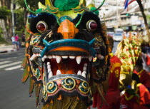 Thailand, Bangkok, Dragon Dance head carried in parade celebrating local temple on New Road , first paved road in the city.