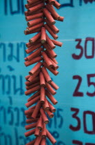 Thailand, Bangkok, Firecrackers celebrating local temple in front of Thai script on menu board