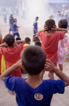 Thailand, Bangkok, Thai boys cover their ears watching firecrackers exploding at local temple.