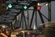 Thailand, Bangkok, Traffic flow control in evening rush hour on Saphan Phut Memorial Bridge, illuminated temple stupa in the background.