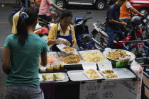 Thailand, Bangkok, Street vendor and daughter sell take away Pad-thai the national fried noodle classic dish.