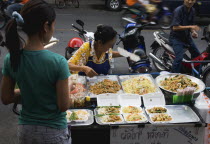 Thailand, Bangkok, Street vendor and daughter sell take away Pad-thai the national fried noodle classic dish.