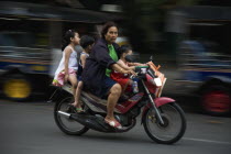 Thailand, Bangkok, Mother with three young children on motorcycle.
