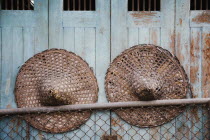 Thailand, Bangkok, Vintage conical straw hats displayed on wall.