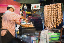 Thailand, Bangkok, Street vendor selling sausages in early evening light, 5 Baht each, cheapest food in the city.