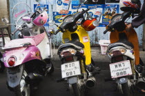 Thailand, Bangkok, Brightly coloured motorcycle scooters and helmets.