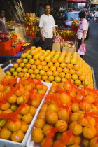 Thailand, Bangkok, Stallholder attending oranges on stall for Chinese New Year.