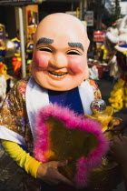 Thailand, Bangkok, Member of dance troupe with papier mache character head and fan for Chinese New Year show.
