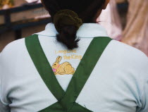 Thailand, Bangkok, Thai woman wears shirt with Long live the King embroidery, and Rabbit for year 2011, a symbol of peace.