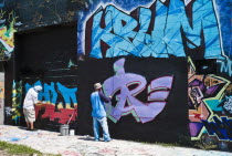 USA, Florida, Orlando, Graffiti artists painting wall.