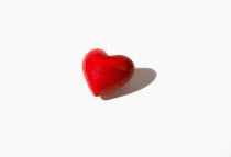 Heart, Red heart shaped stone against white background.