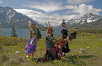 Canada, Alberta, Waterton Lakes NP, Blackfoot Indians dressed for a Pow Wow with Middle and Upper Waterton Lakes the Rocky Mountains and the Prince of Wales Hotel in the background. The park is a UNES...