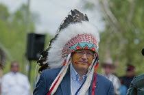 Canada, Alberta, Stand Off, Canada's Prime Minister, Stephen Harper, with face painted and in ceremonial headdress of Eagle feathers and beadwork having just been inducted as a Chief of the Kainai or...