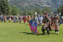 Canada, Alberta, Waterton Lakes National Park, Grand Entry of dancers in full regalia at the Blackfoot Arts & Heritage Festival Pow Wow organized by Parks Canada and the Blackfoot Canadian Cultural So...
