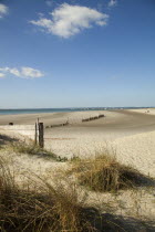 England, West Sussex, West Wittering Beach, View across sand dunes towards beach and sea at East Head. Sunshine and blue sky.