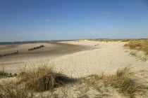 England, West Sussex, West Wittering Beach, View across sand dunes towards beach and sea at East Head. Sunshine and blue sky.