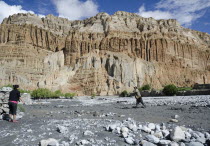 Nepal, Upper Mustang, Chhusang locals use appropriate stones from the Kali Gandaki riverbed to rebuild the stone wall around the village.