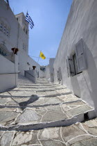 Greece, Cyclades, Islands, Sifnos Island, Apollonia Town, Portrait format low angle photograph of a typical alley found only at Cyclades island complex with the church of Agios Spyridonas on the left...