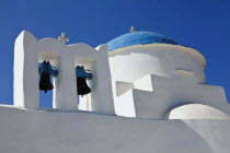 Greece, Cyclades Island, Sifnos, Traditional small white church with a blue dome, white crosses and old copper made bells.