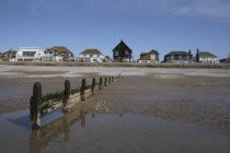 England, Kent, Camber Sands, seafront houses from beach with groyne in foreground.