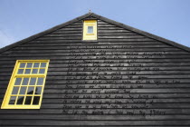 England, Kent, Romney Marsh, Dungeness, Detail of building gable wall with words carved from wood.