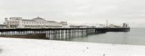 England, East Sussex, Brighton, Pier during winter with snow on the beach.