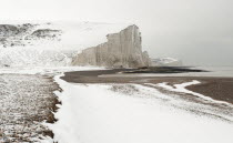 England, East Sussex, Seven Sisters, Snow covered chalk cliffs viewed from the coastguard cottages at Cuckmere Haven.