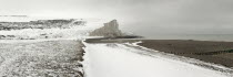 England, East Sussex, Seven Sisters, Snow covered chalk cliffs viewed from the coastguard cottages at Cuckmere Haven.