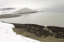 England, East Sussex, Seven Sisters, Snow covered chalk cliffs viewed from the coastguard cottages at Cuckmere Haven.