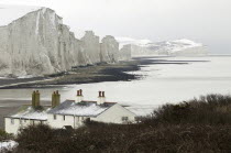 England, East Sussex, Seven Sisters, Snow covered chalk cliffs viewed from the coastguard cottages at Cuckmere Haven.