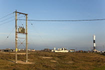 England, Kent, Romney Marsh, Dungeness, View toward the Light Railway Cafe with power cables in the foreground.