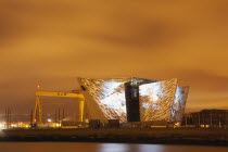 Ireland, North, Belfast, Titanic Quarter, Visitor centre designed by Civic Arts & Eric R Kuhne, illuminated at night.