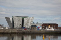 Ireland, North, Belfast, Titanic Quarter, Visitor centre designed by Civic Arts & Eric R Kuhne, with the launch SS Nomadic in the foreground.