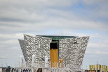 Ireland, North, Belfast, Titanic Quarter, Visitor centre designed by Civic Arts & Eric R Kuhne, with funnel of SS Nomadic in the foreground.