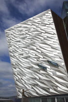 Ireland, North, Belfast, Titanic Quarter, Visitor centre designed by Civic Arts & Eric R Kuhne, with statue of diving woman in foreground.