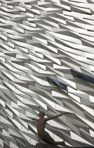 Ireland, North, Belfast, Titanic Quarter, Visitor centre designed by Civic Arts & Eric R Kuhne, with statue of diving woman in foreground.